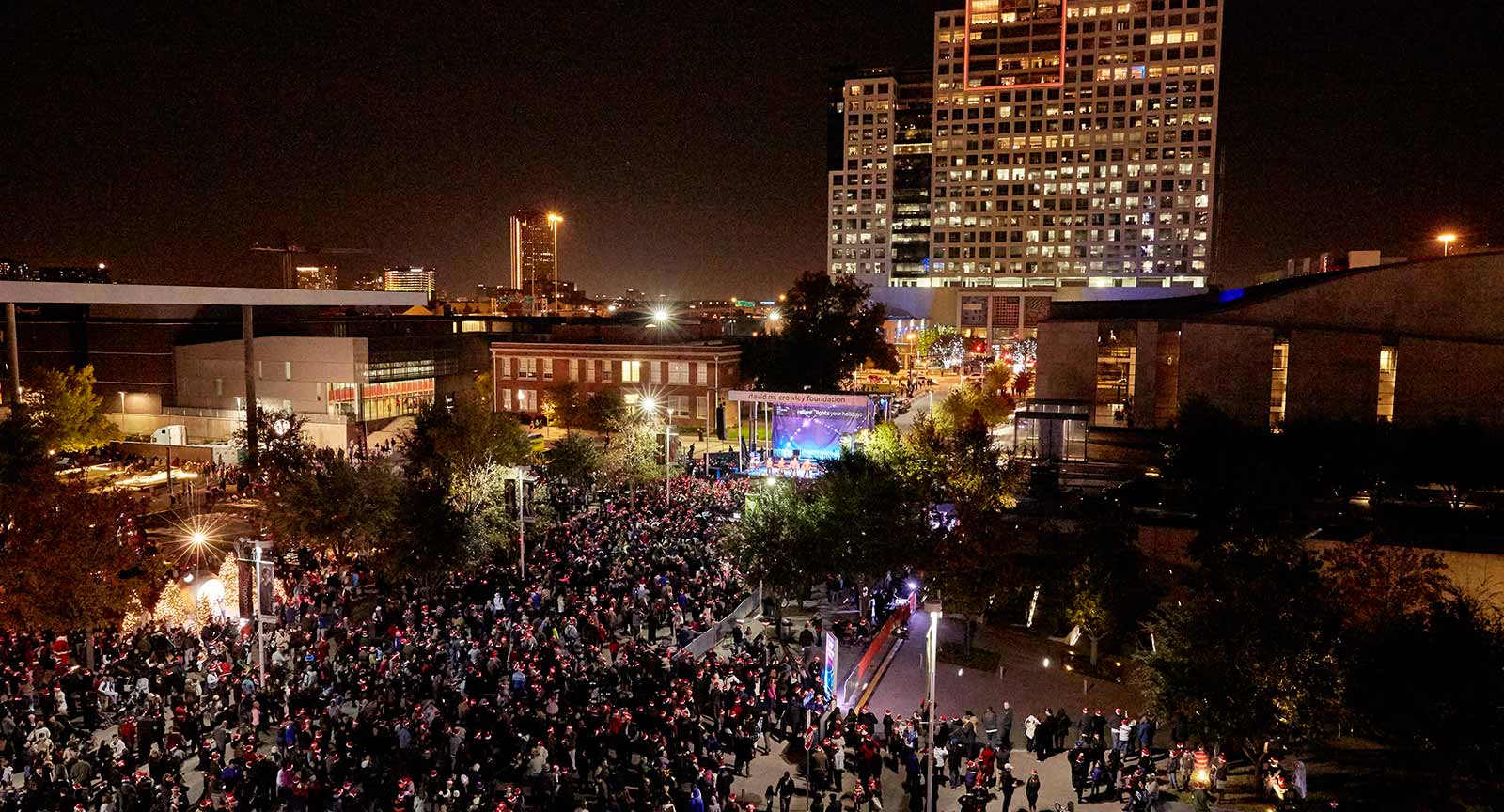 Crowds gather for a holiday concert in the Arts District at night